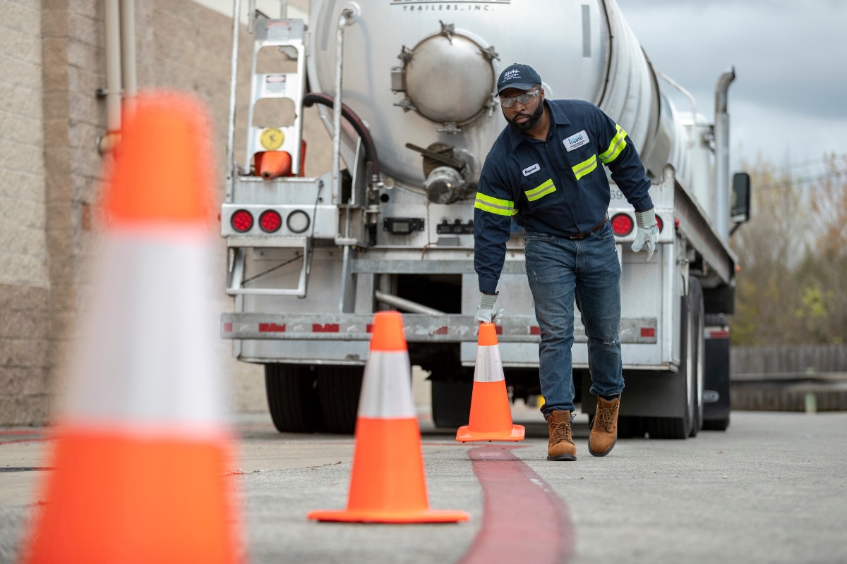 An LES technician setting safety cones behind a service truck