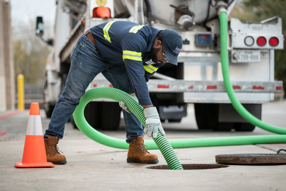 An LES technician pumping a grease trap
