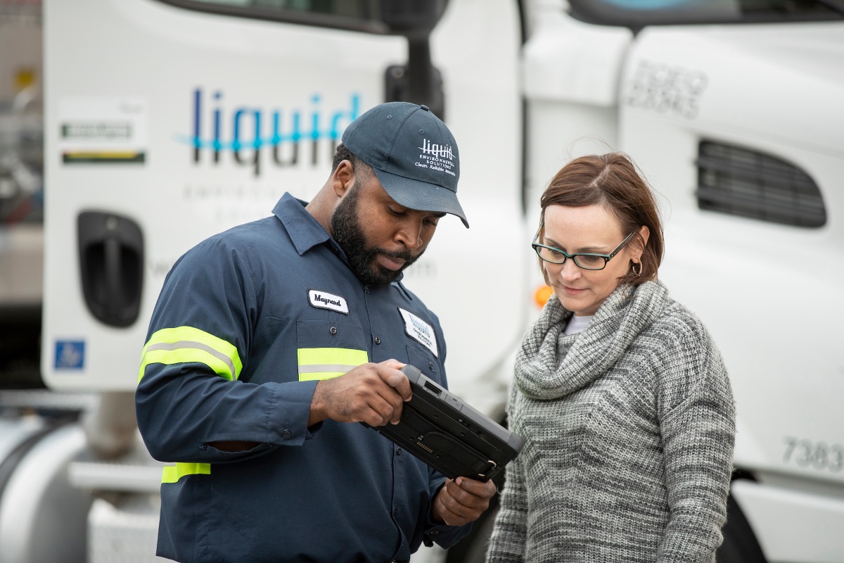 An LES technician reviews service documentation with a customer